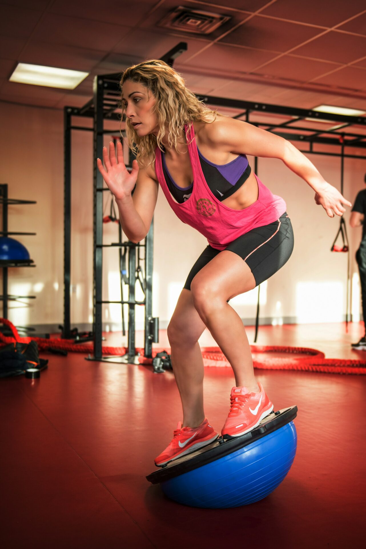 A woman balancing on a BOSU ball during her workout to improve stability and core strength.