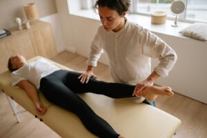 A physiotherapist performing a deep tissue thigh massage to aid recovery, flexibility, and exercise rehabilitation.