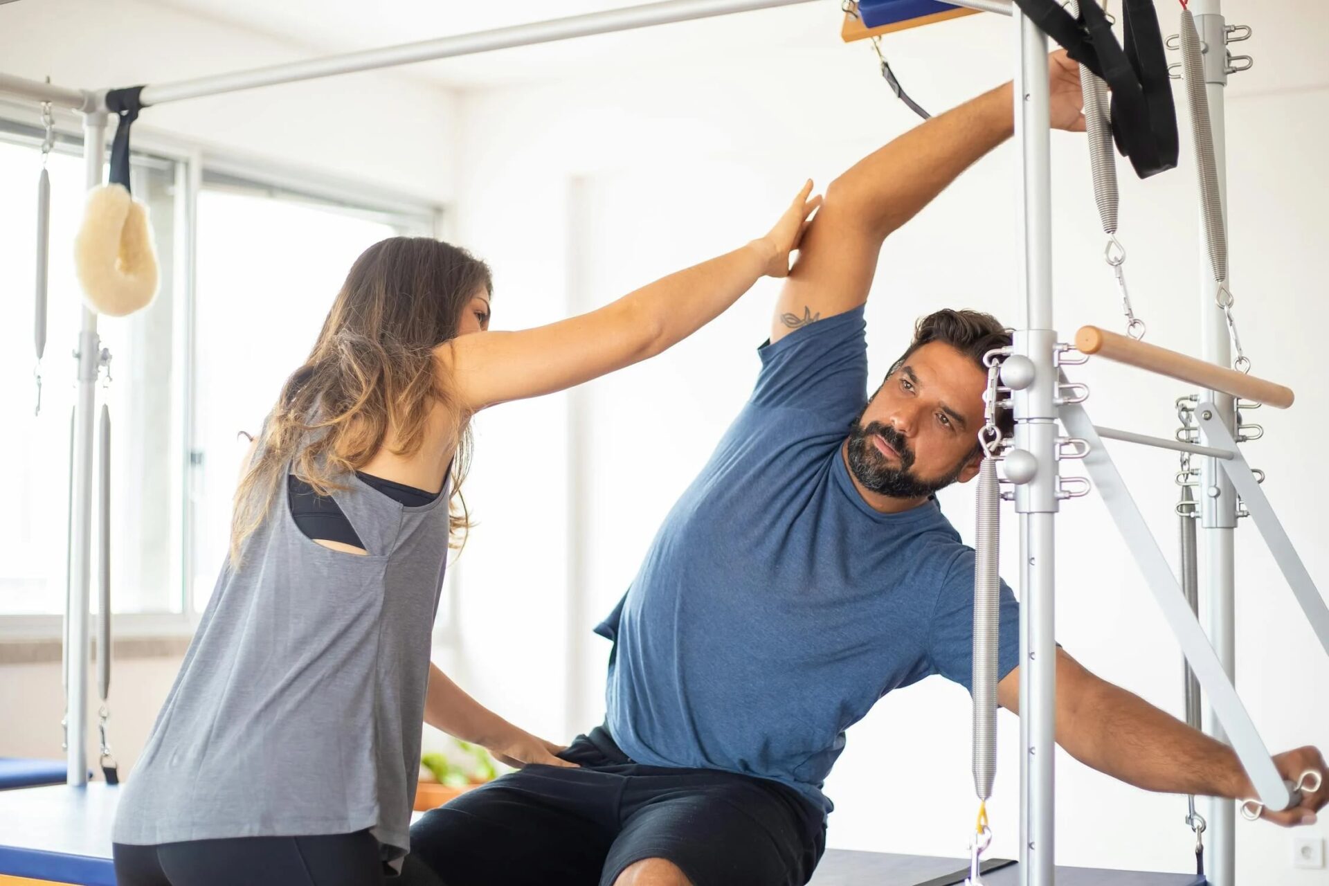 A person performing strength training exercises under the guidance of an exercise physiologist in a clinical setting.