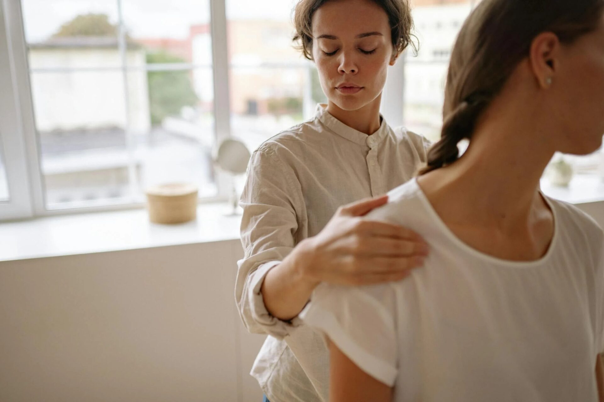An exercise physiologist assessing a patient’s back during a clinical evaluation.