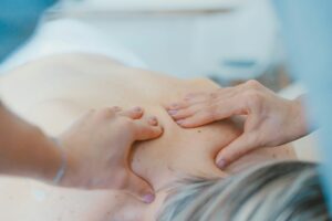 Close-up of an exercise physiologist performing a back massage to relieve tension and improve musculoskeletal health.